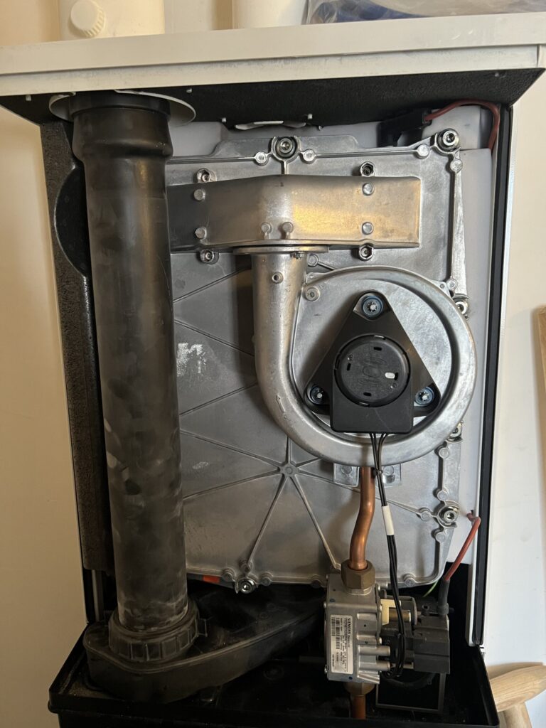 Geopende cv-ketel met brander, ventilator en gasblok