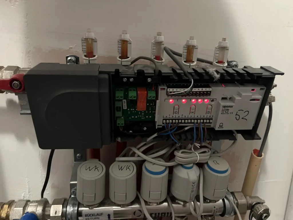 Vloerverwarmingsverdeler met regelunit aan de wand